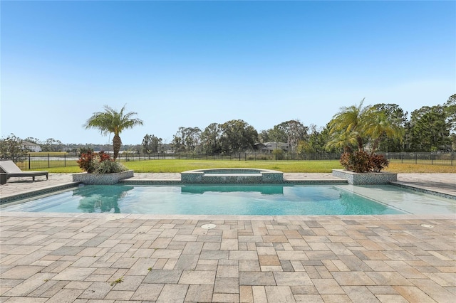 view of swimming pool featuring a pool with connected hot tub, fence, and a yard