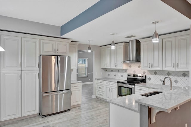 kitchen with wall chimney exhaust hood, kitchen peninsula, a breakfast bar area, pendant lighting, and appliances with stainless steel finishes