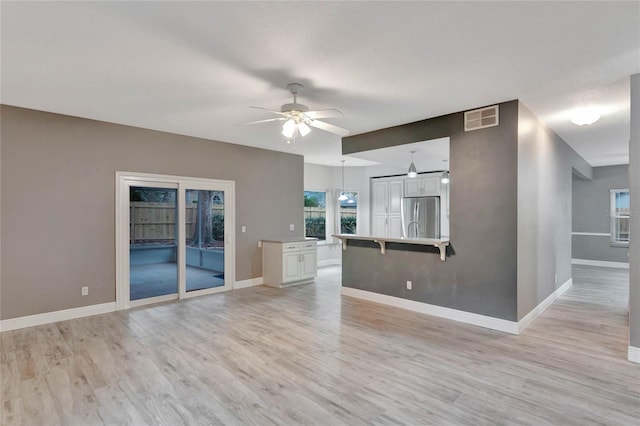 unfurnished living room featuring light wood-type flooring and ceiling fan