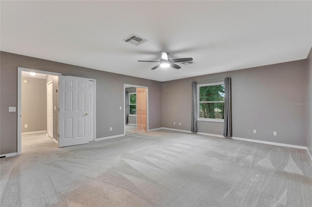 unfurnished bedroom featuring ensuite bathroom, ceiling fan, and light carpet