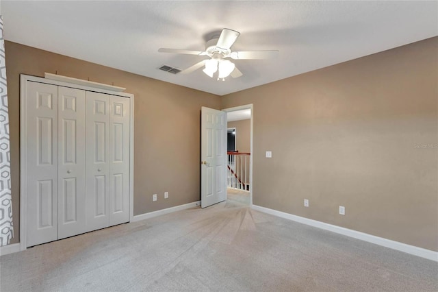 unfurnished bedroom featuring ceiling fan, light colored carpet, and a closet