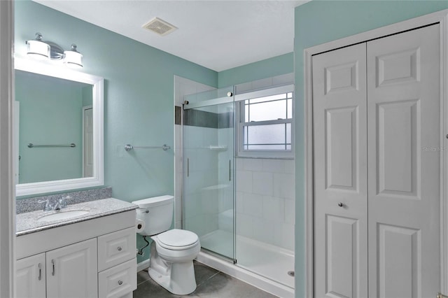 bathroom with toilet, tile patterned flooring, a shower with door, and vanity