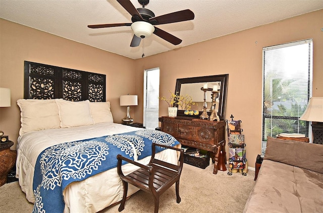 carpeted bedroom featuring a textured ceiling and ceiling fan