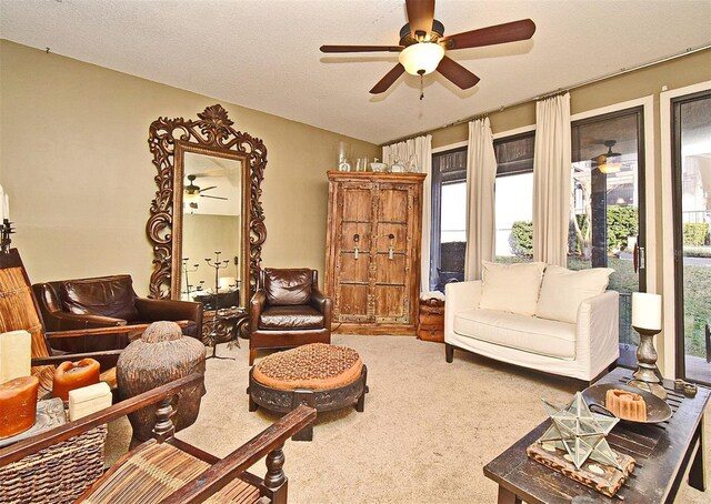 carpeted living room featuring ceiling fan and a textured ceiling