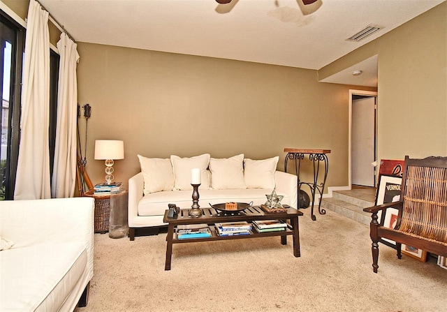 carpeted living room with ceiling fan