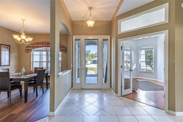 tiled foyer with an inviting chandelier