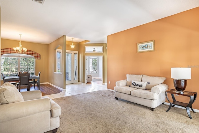 carpeted living room featuring a wealth of natural light and a chandelier