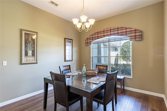 dining space with dark hardwood / wood-style flooring and a notable chandelier