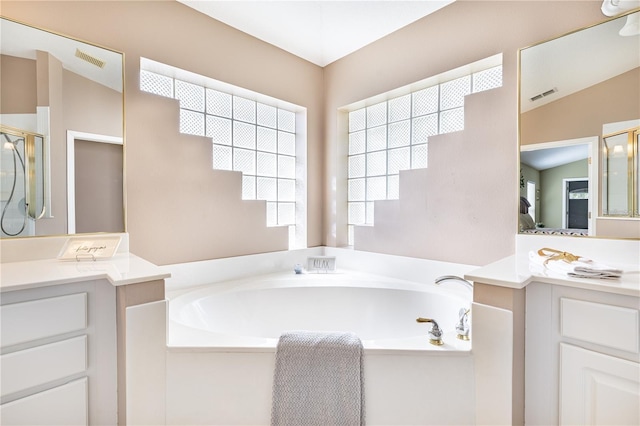 bathroom with lofted ceiling, vanity, and independent shower and bath