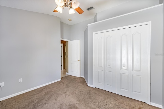 unfurnished bedroom with ceiling fan, a closet, and light colored carpet