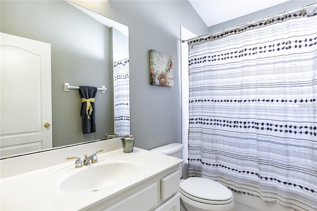 bathroom featuring vanity, toilet, and lofted ceiling