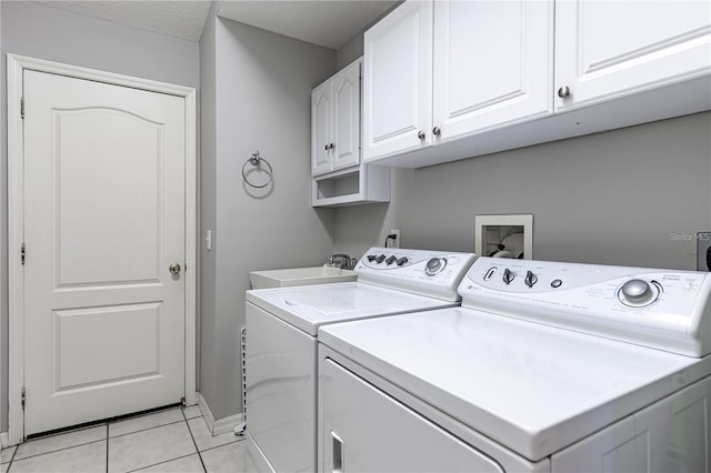 washroom with cabinets, a textured ceiling, sink, independent washer and dryer, and light tile patterned flooring