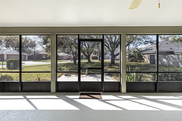 unfurnished sunroom with ceiling fan