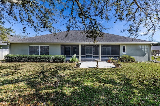 back of house featuring a lawn, a sunroom, and a patio area