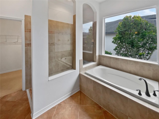 bathroom featuring tiled bath and tile patterned floors