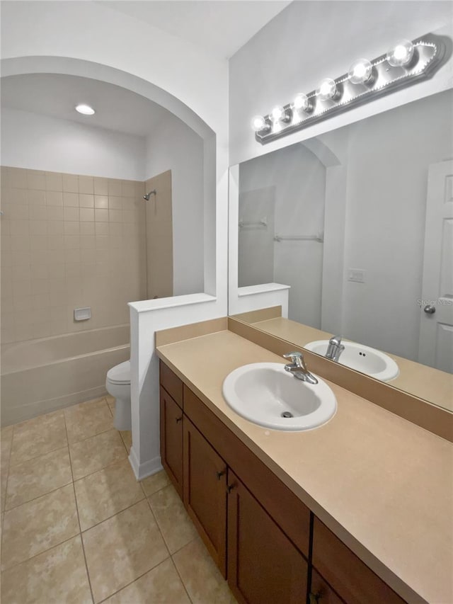 full bathroom with vanity, tile patterned flooring, tiled shower / bath combo, and toilet