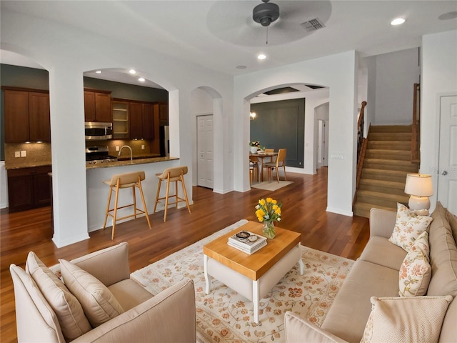 living room featuring dark hardwood / wood-style flooring and ceiling fan