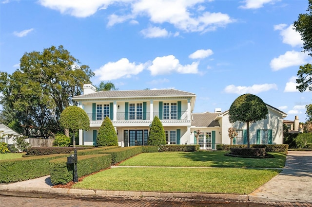 view of front of house featuring a front yard, french doors, and a balcony