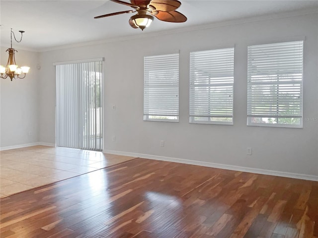 unfurnished room featuring ceiling fan with notable chandelier, ornamental molding, and hardwood / wood-style flooring