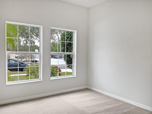 unfurnished room with a wealth of natural light and carpet