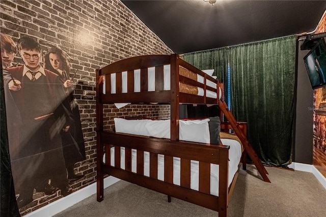 bedroom with carpet flooring, brick wall, and lofted ceiling