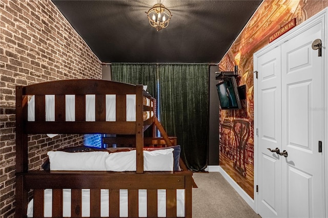 bedroom featuring carpet, vaulted ceiling, a closet, and brick wall