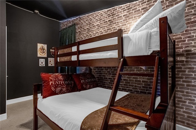 carpeted bedroom featuring brick wall