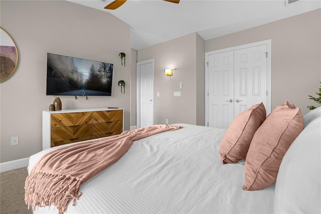 carpeted bedroom with ceiling fan, a closet, and lofted ceiling