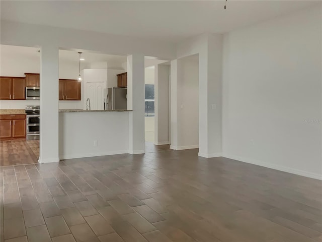 unfurnished living room featuring sink and dark hardwood / wood-style floors