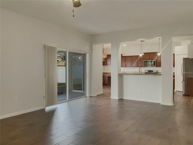 unfurnished living room with ceiling fan and sink