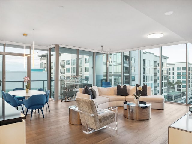 living room featuring expansive windows, a healthy amount of sunlight, and hardwood / wood-style flooring