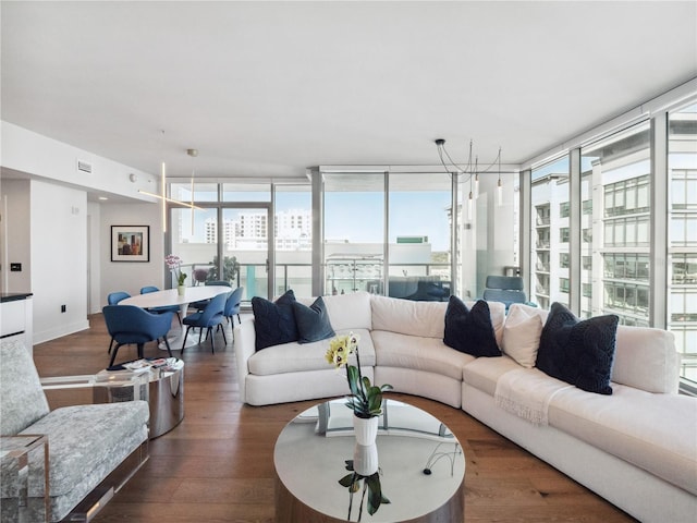 living room with dark hardwood / wood-style flooring, a wealth of natural light, and floor to ceiling windows