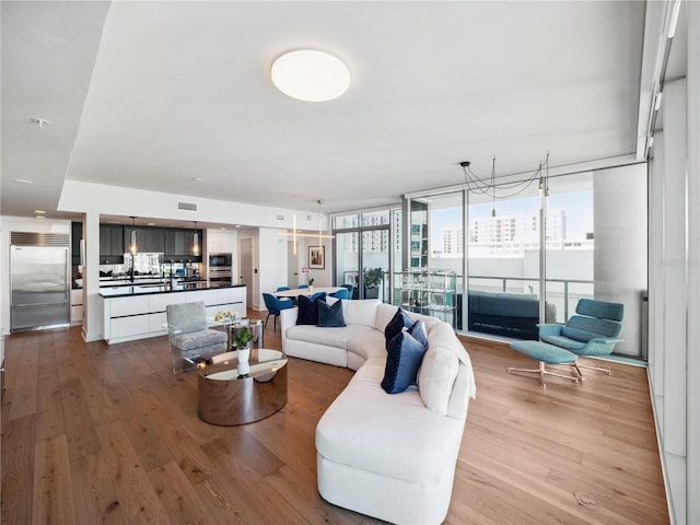 living room with light hardwood / wood-style flooring and a wall of windows