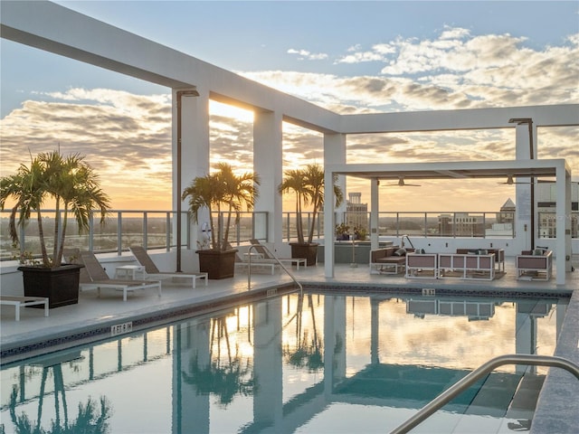 pool at dusk featuring a patio area