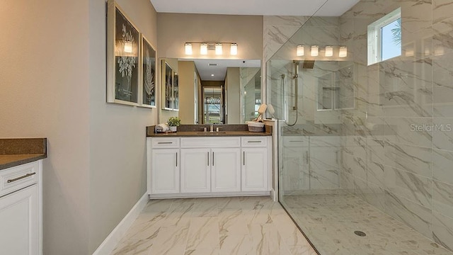 bathroom with a tile shower and vanity