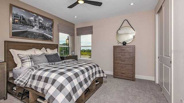 carpeted bedroom featuring ceiling fan and a closet