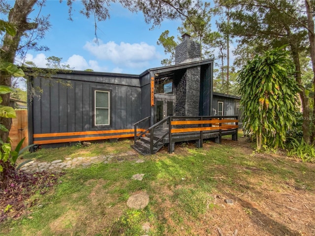 back of house featuring a yard and a wooden deck