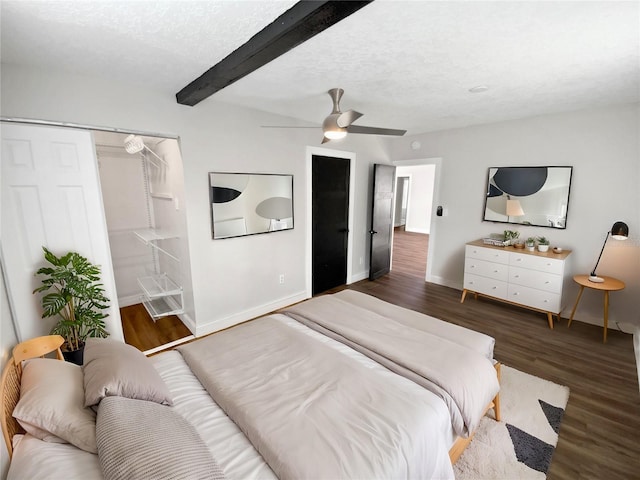 bedroom with a closet, ceiling fan, dark hardwood / wood-style flooring, a textured ceiling, and beam ceiling