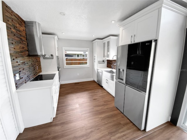 kitchen featuring stainless steel appliances, white cabinetry, wall chimney exhaust hood, decorative backsplash, and dark hardwood / wood-style floors