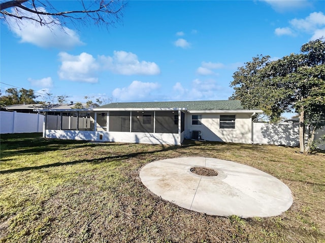 back of property featuring a lawn, an outdoor fire pit, a sunroom, and a patio area