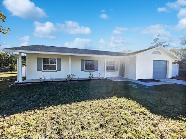 ranch-style house featuring a front yard, covered porch, and a garage