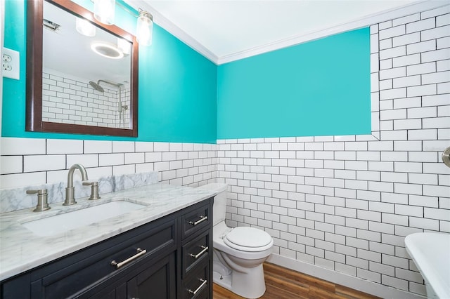 bathroom with tile walls, crown molding, wood-type flooring, and vanity