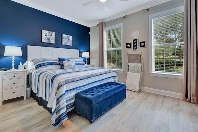 bedroom featuring ceiling fan, ornamental molding, light hardwood / wood-style floors, and multiple windows