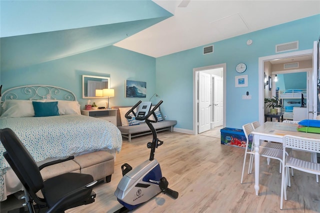 bedroom featuring light wood-type flooring and lofted ceiling