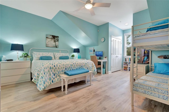 bedroom with ceiling fan, lofted ceiling, a closet, and light hardwood / wood-style flooring