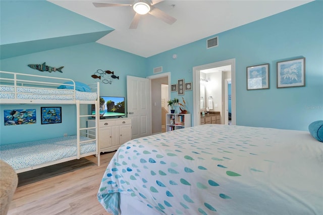 bedroom with ceiling fan, lofted ceiling, ensuite bathroom, and light hardwood / wood-style flooring