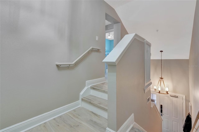 staircase with lofted ceiling and a chandelier