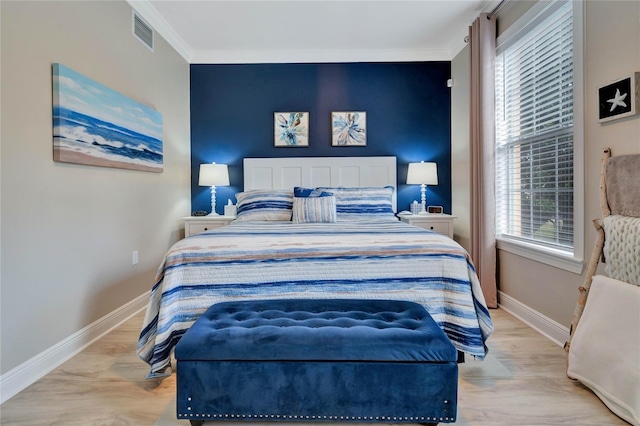 bedroom featuring crown molding and light hardwood / wood-style flooring