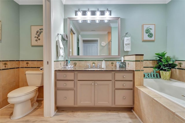 bathroom with vanity, tile walls, toilet, ornamental molding, and a relaxing tiled tub