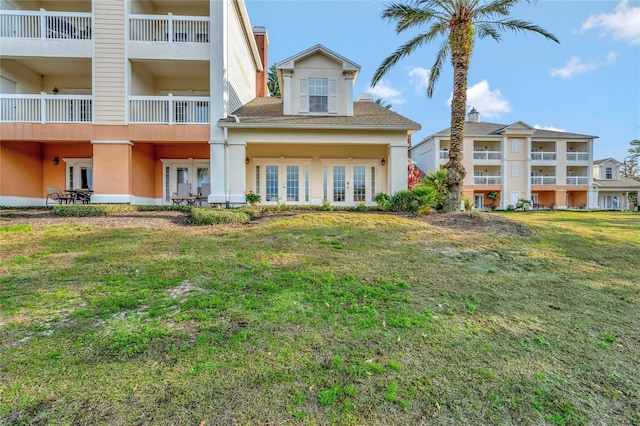 rear view of house featuring french doors and a yard